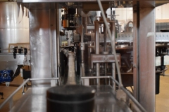 Standing at the left end of the bottling machine pictured previously, looking into the conveyor track.